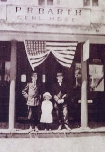 The flag with 48 stars is the only indication of how old this photo of the Barth store is. 48-star flags were flown from 1912 to 1959.