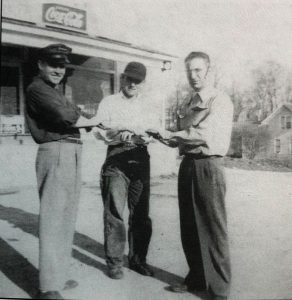 John Putnam, Ed Egler Jr. and Myles Kimmerly standing in front of Kimmerly's Grocery. - Courtesy of Leelanau Historical Society