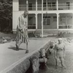 Standing on the dock in what looks like his bathrobe is Norm Johanning. It does look like what we today call a bath robe. But perhaps it was considered a proper male cover up in the early 1950's. The folks from the 1950's might consider our clothing questionable as well! The lady in the water is Jane Saxton. - Photo credit Omena Historical Society Standing on the dock in what looks like his bathrobe is Norm Johanning. It does look like what we today call a bath robe. But perhaps it was considered a proper male cover up in the early 1950's. The folks from the 1950's might consider our clothing questionable as well! The lady in the water is Jane Saxton. - Photo credit Omena Historical Society