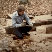 Tom Mastick shaving down the base of a post to fit in a hole he had made for it in the sub flooring. Tom Mastick shaving down the base of a post to fit in a hole he had made for it in the sub flooring.